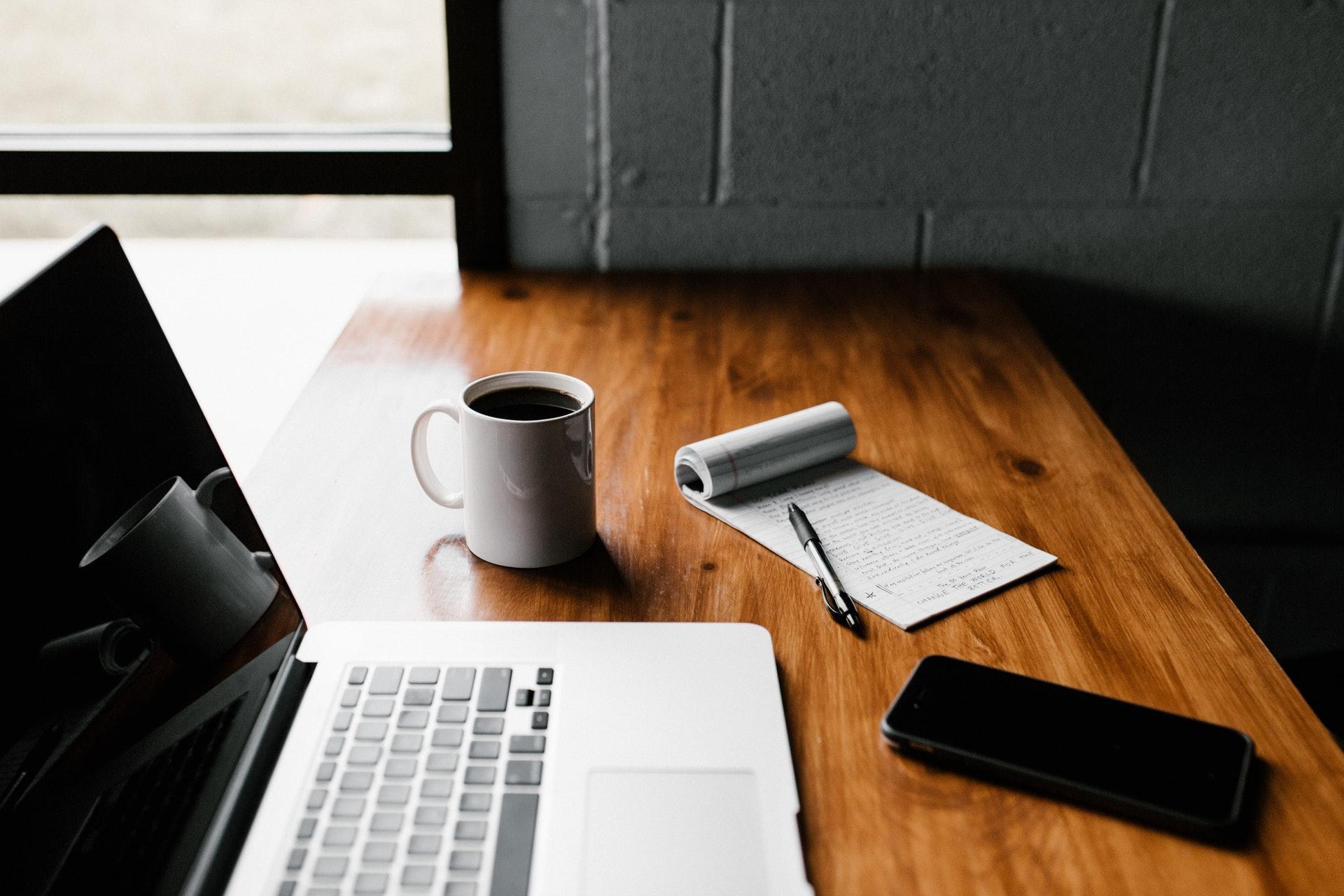 Desk with a laptop and notepad with a list of ideas to attract new customers
